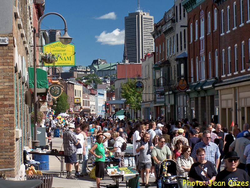 Photo : sur la rue Saint-Vallier, des centaines de personnes déambules pour un marché public, au gros soleil!  Photo de Jean Gazes.